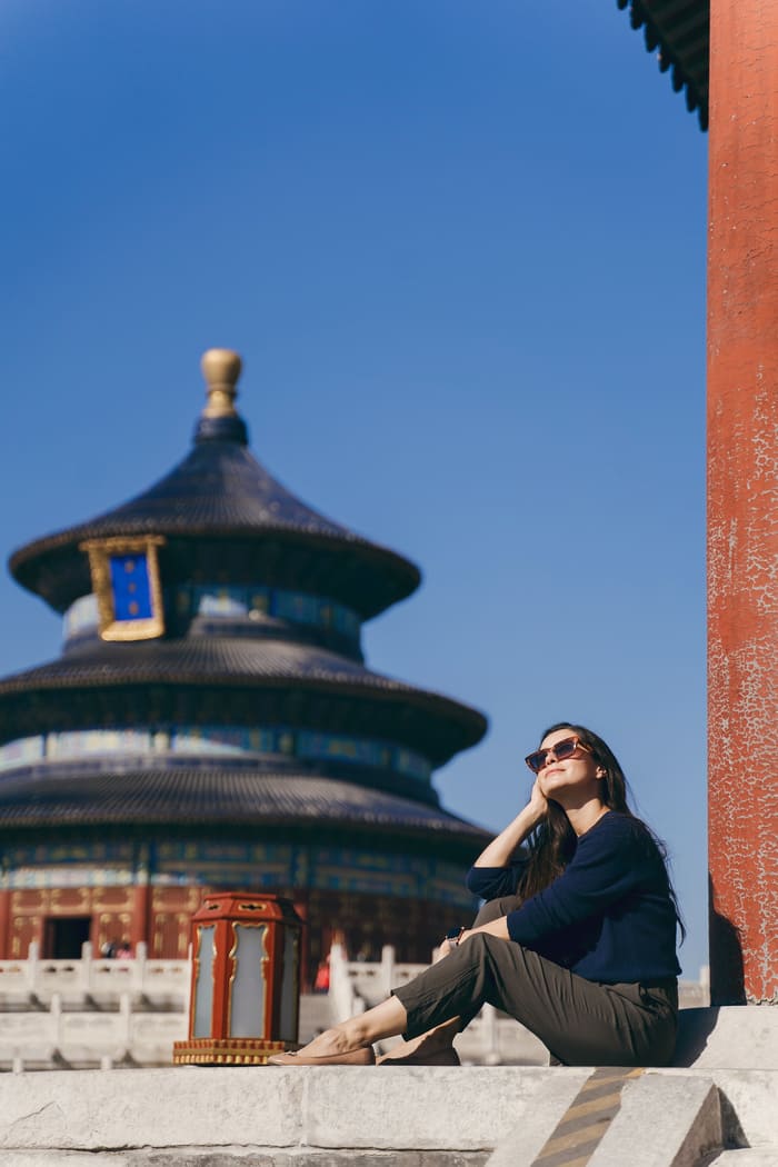 viaje a bejing china turista sentada viendo el cielo azul con lentes obscuros y relajada