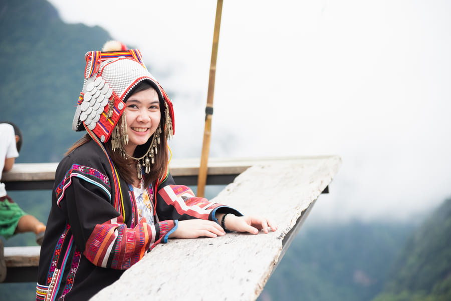 mujer con traje tipico de china, en un puente de madera